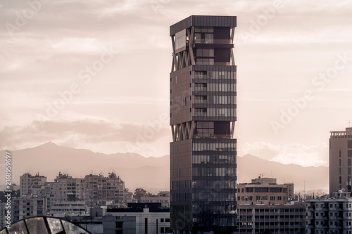 Skyscraper standing tall over Nicosia city skyline at dusk with mountains in the background