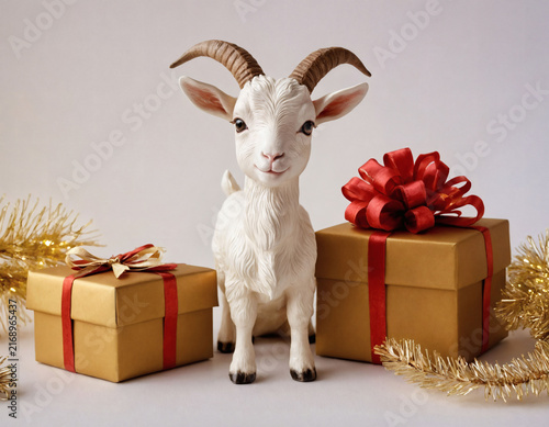A charming figurine of a white goat, standing between golden gift boxes tied with red ribbons, embodies the symbol of the Chinese New Year the goat