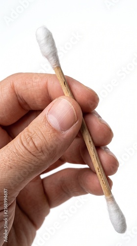 A hand holding a cotton swab made of wood and cotton