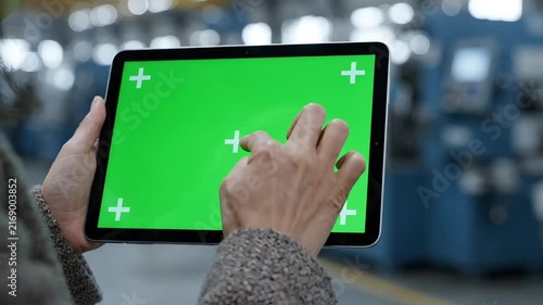 Hands holding green screen tablet outdoors in sunny park