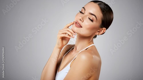 Ethereal Beauty: A serene woman with flawless skin and closed eyes touches her chin gently, radiating an aura of peace and self-care.
