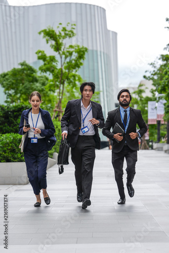 Canvas Print An Asian businessman, an Indian businessman and a European businesswoman walk th