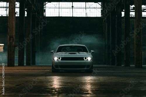 Cinematic muscle car parked in industrial warehouse