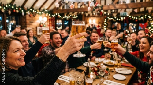 Friends celebrating Christmas party with beer toast in cozy pub decorated with festive lights and garlands