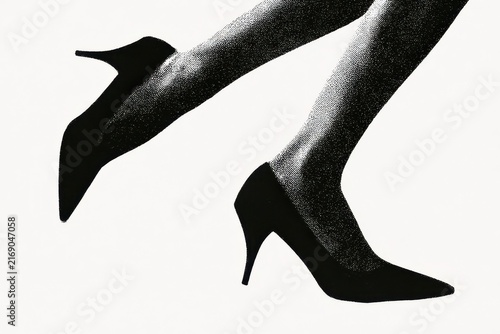Close up of a womans legs wearing high heels isolated on white background