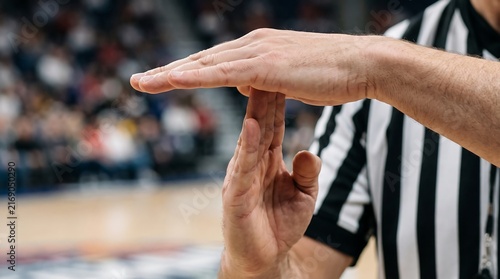 Basketball referee hands making time out signal in stadium