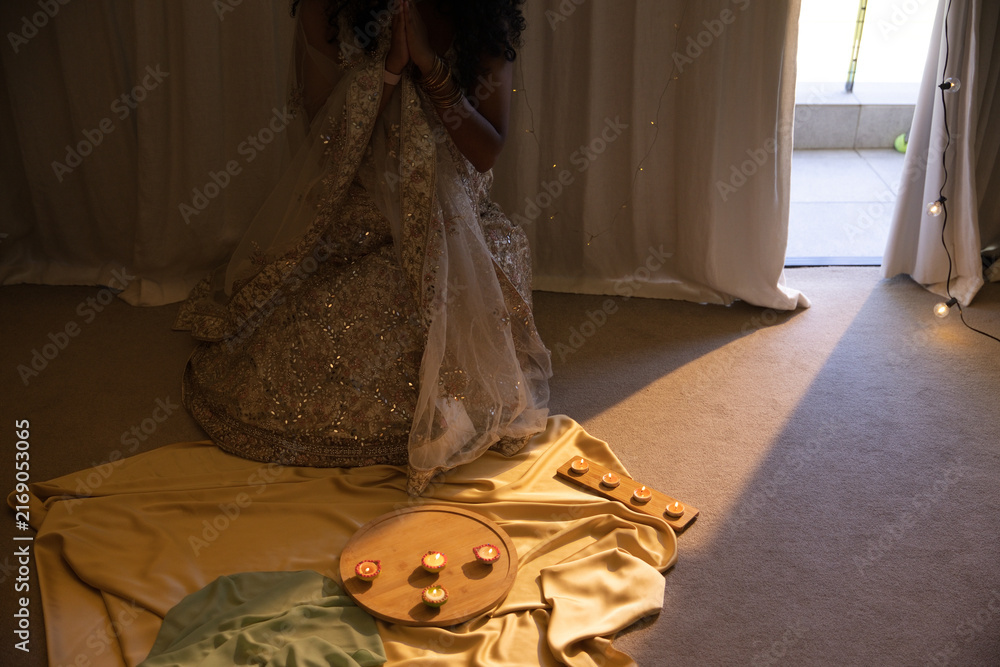 Fototapeta premium Wooden tray is holding lit lamps on golden cloth near sliding door with sunlight