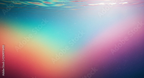 An abstract underwater view showcases a vibrant spectrum of colors blending blues greens pinks and oranges