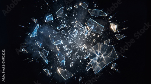 sharp shards of broken glass exploding violently through the air, hundreds of crystal fragments suspended in dynamic motion