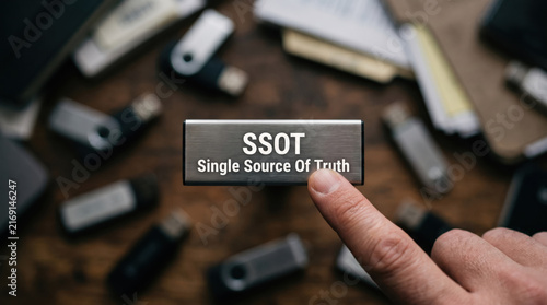 SSOT single source of truth USB flash drive, finger touching metal memory stick, big data business concept, computer storage media, technology selection closeup