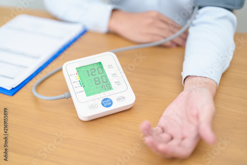 Man checking Blood pressure by Blood pressure monitor with Cuff. Systolic, SYS, Diastolic, DIA, Pulse, Hypertension, Hypotension, Heart rate, Cardiovascular Disease and May World hypertension day