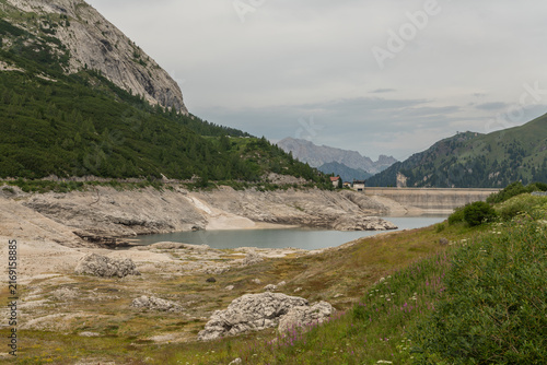 Canazei, Italy. Lago di Fedaia reservoir with exposed shoreline and low water level caused by drought in the Dolomites