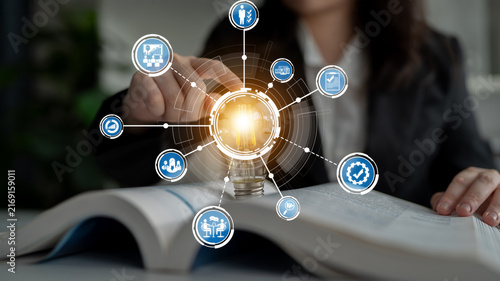 Fotografie A focused businesswoman interacts with digital technology, showcasing icons representing innovative ideas