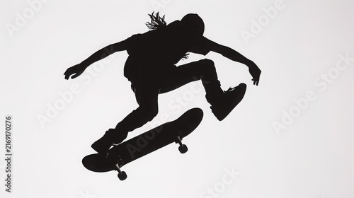 Plakat Skateboarder performing a trick in mid-air against a white background.