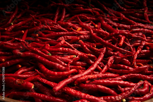 Canvastavla Dramatic low-key close-up of a dense pile of fiery red cayenne chili peppers