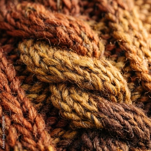 Macro close up thick woven yarn braided rope warm brown mustard orange autumn colors cozy fabric texture