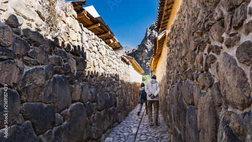 Canvas Print People are walking along a narrow paved street