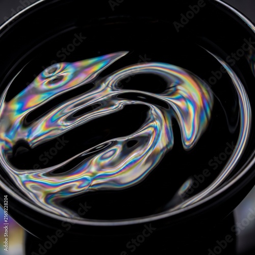 Rainbow Spectrum Reflections Across Black Liquid Surface