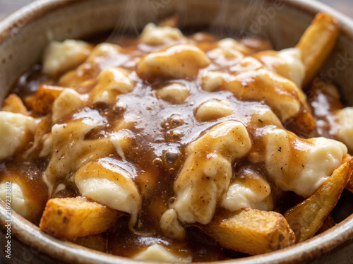 Authentic Canadian poutine with crispy french fries melted cheese curds and hot brown beef gravy