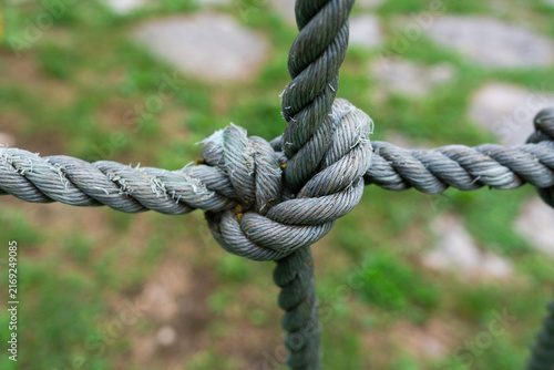 Obraz na płótnie Detailed macro shot of a strong rope knot tied in a grid pattern on a blurred background concept for security, connection, network infrastructure, reliable teamwork
