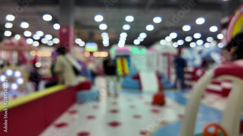 Abstract blurred background of colorful indoor children playground with bright bokeh lights.