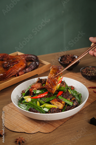 Foto Air-Dried Duck Delicacy Traditional Preserved Meat Dish with Chopsticks and Vege