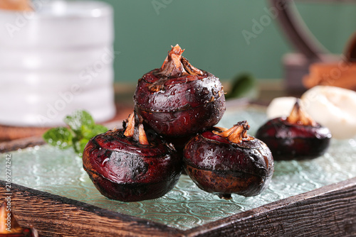Roasted Red Onions on Rustic Wooden Board in Farmhouse Kitchen Setting