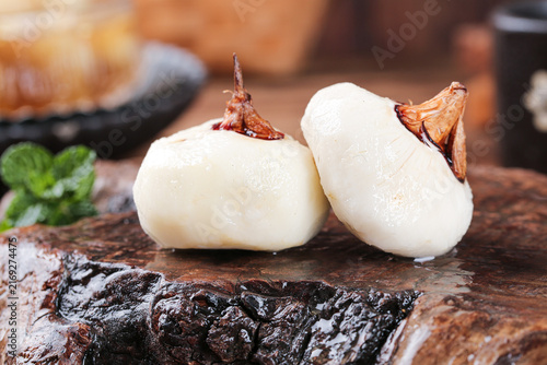 Fresh Peeled Garlic Cloves on Rustic Wooden Cutting Board in Farmhouse Kitchen
