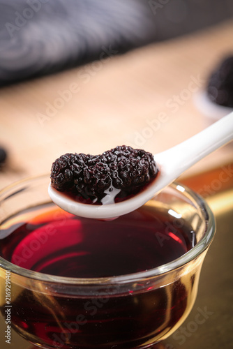 Foto Dried Xinjiang Mulberries on Spoon with Herbal Tea - Traditional Chinese Superfo