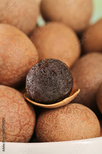 фотографія Fresh Longan Fruit with Dried Meat Core Visible in Shell on White Background