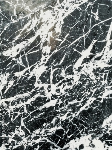 This photo shows a dark-colored marble surface with naturally occurring white veins spreading across it.