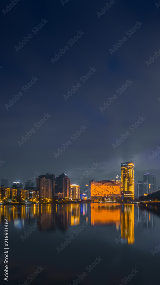 Fototapeta premium Wuhan night skyline with Hanxiu Theater reflected on the lake