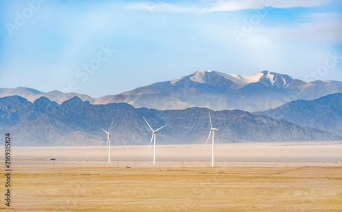 Foto Wind Turbines in Desert Landscape with Mountain Vista