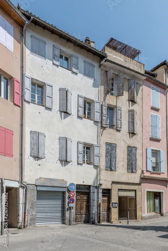 old traditional buildings on bending street in town central district, Digne, France