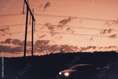 Cinematic vintage illustration of car with headlights on under sunset sky and power lines