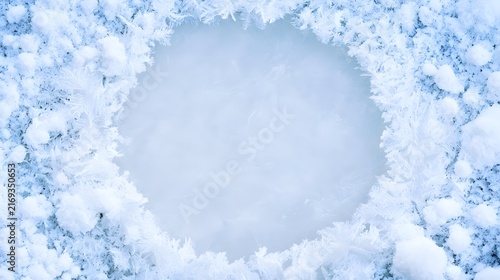 Top down macro of crystalline snowflakes forming a circular frame on smooth frozen icy surface texture