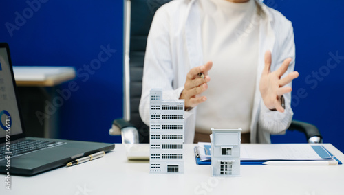 Fotografie Salesman Hands On House Model , Small Toy House Small Mortgage Property insurance and concepts real estate