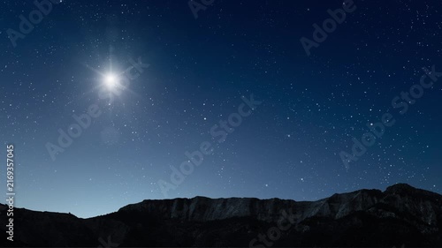 Glowing Christmas star above a peaceful mountain landscape with night sky