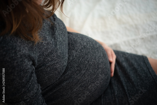 Konstfotografi Beautiful close-up of pregnant belly with gentle hands tenderly cradling baby bump