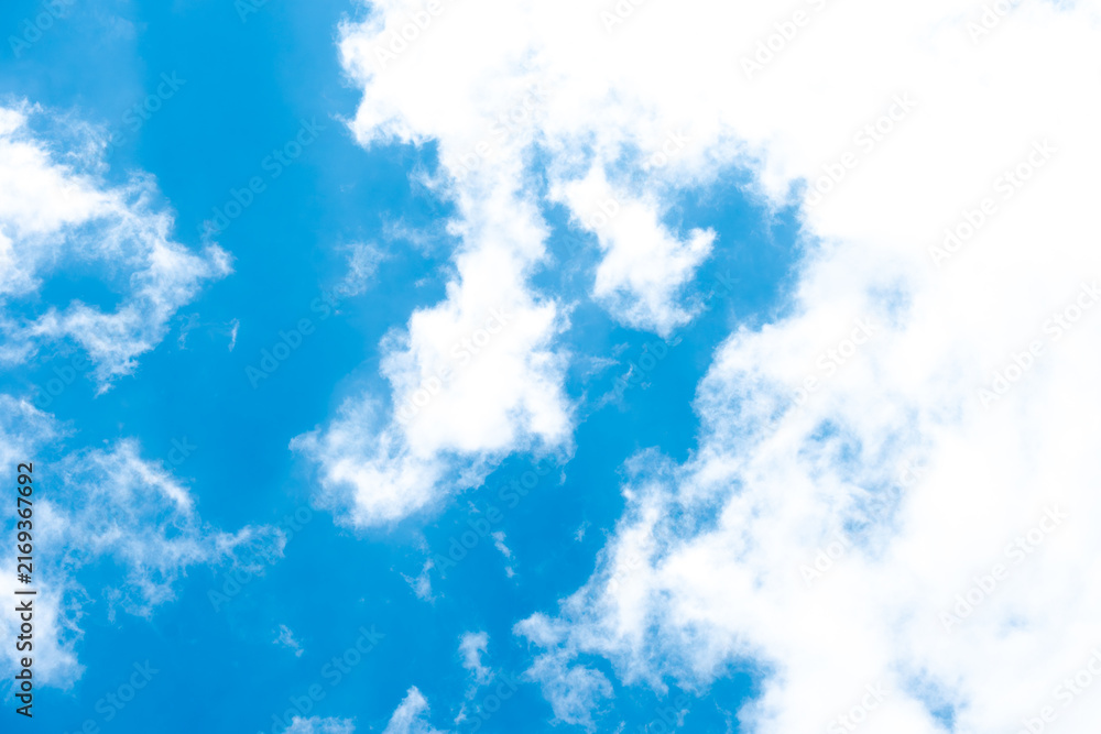 Fototapeta premium A vibrant azure blue sky filled with scattered white cumulus clouds. The natural daylight creates a bright, serene atmosphere, ideal for uplifting backgrounds and creative design use.