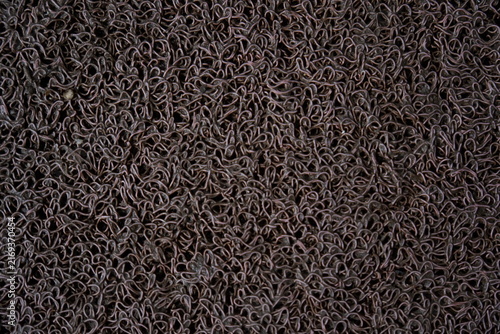 Brown textured rubber door mat surface, close up of non-slip floor covering material.