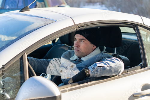 Принти на полотні Calm male driver waiting behind the wheel with hands on the steering wheel, focused on the road