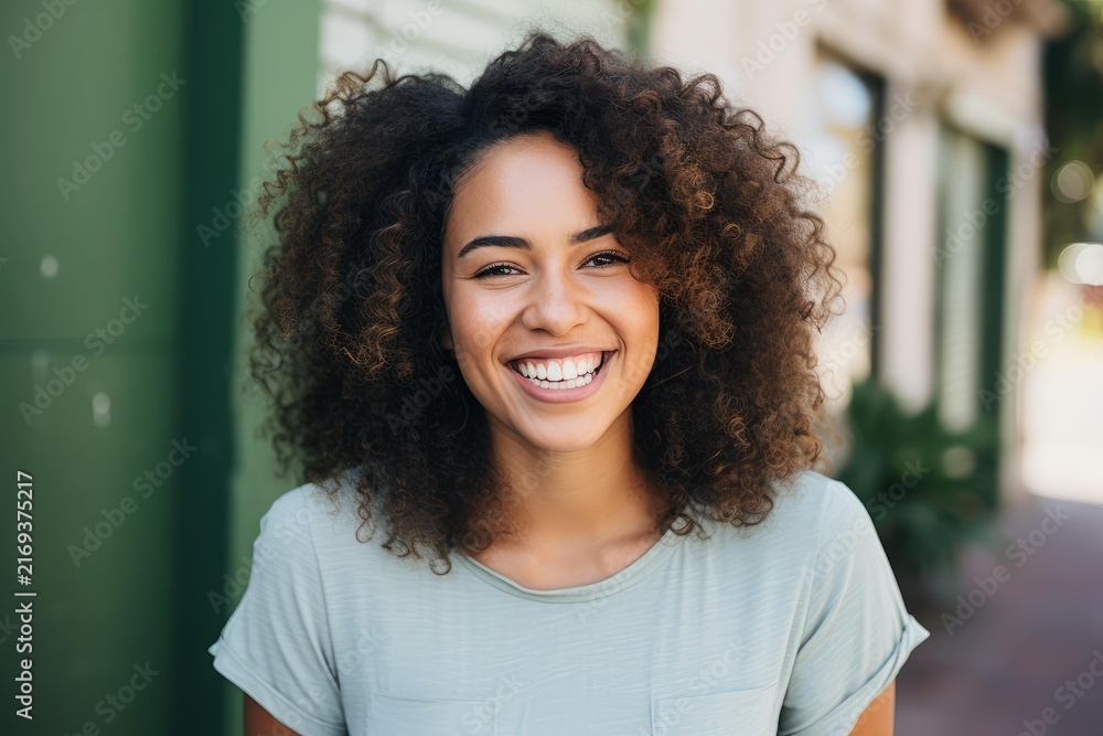 Fototapeta premium Young mixed race woman smiling broadly looking at camera with curly hair