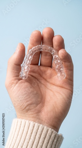 Obraz na płótnie Close-up on hand holding clear invisible orthodontic aligner tray for teeth straightening treatment.