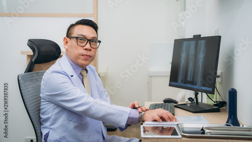An orthopedic doctor explains the patient's bone condition using an X-ray plate, guiding them through the diagnosis and treatment options