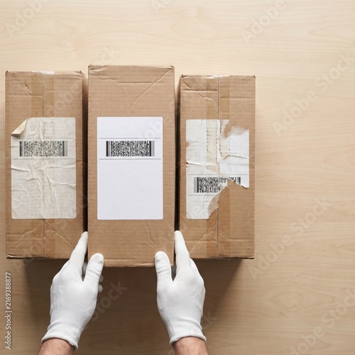 Overhead parcel label quality comparison with three cartons showing intact, wrinkled, and damaged shipping labels arranged from acceptable to questionable condition