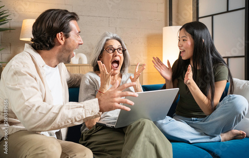Canvastavla Excited family members reacting with joy and surprise while looking at a laptop