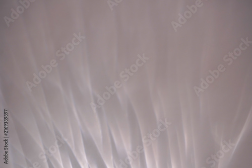 Abstract soft white light refraction and wavy shadow texture on neutral wall background for product mockup.