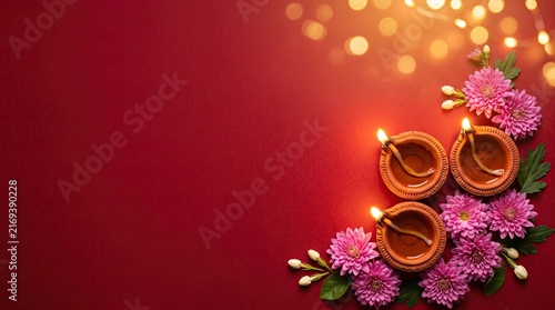 Beautiful diwali background featuring traditional clay oil lamps and vibrant pink flowers on a deep red surface for festival