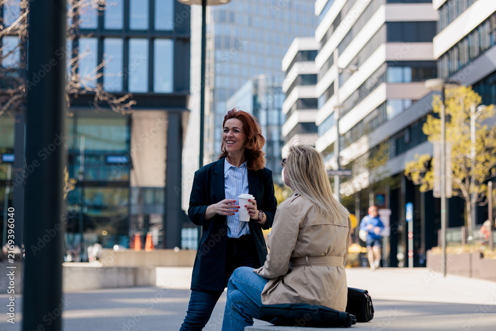 Fototapeta premium Businesswomen talking during coffee break in city